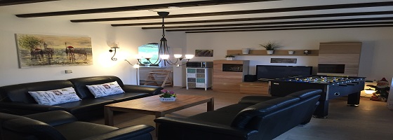 Ferienwohnungen Schmidt: Wohnzimmer EG 43 mit Tischfußball und Ledersesseln